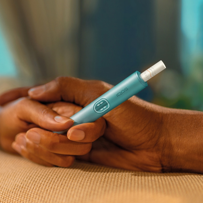 جهاز IQOS ILUMA PRIME في يد شخص، والأضواء مبينة. جهاز IQOS ILUMA PRIME في يد شخص، والأضواء مبينة.