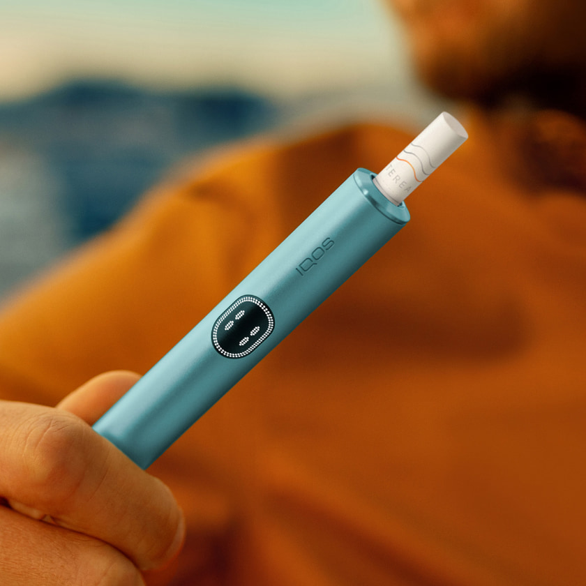 A person places a TEREA stick into an IQOS ILUMA PRIME Holder.  A person places a TEREA stick into an IQOS ILUMA PRIME Holder.