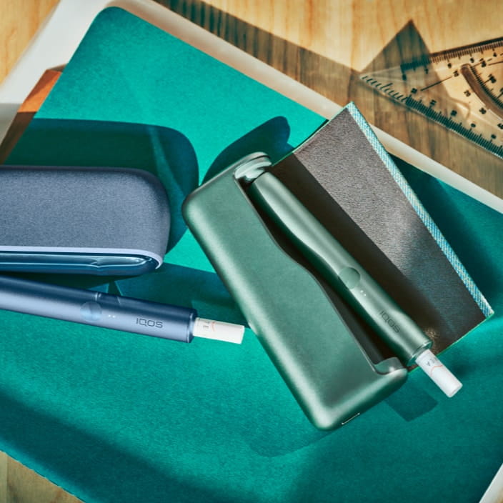  A mid azure blue IQOS ILUMA product sits on an architects desk