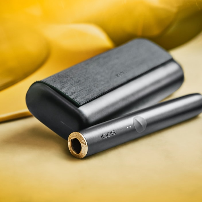 An obsidian black IQOS ILUMA device and holder. An obsidian black IQOS ILUMA device and holder.