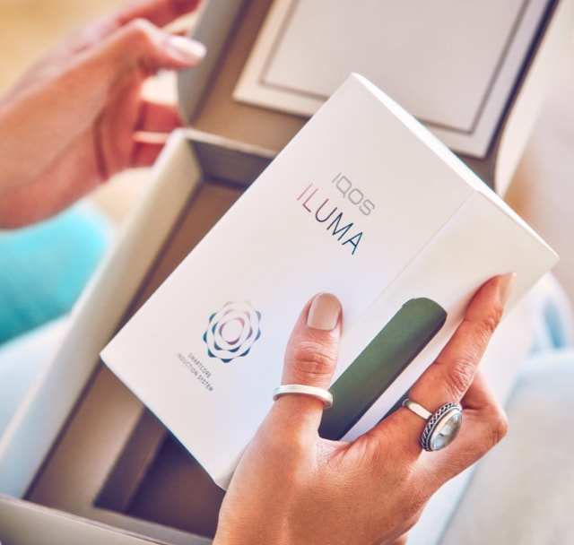 A person opening a box containing a new IQOS ILUMA. A person opening a box containing a new IQOS ILUMA.