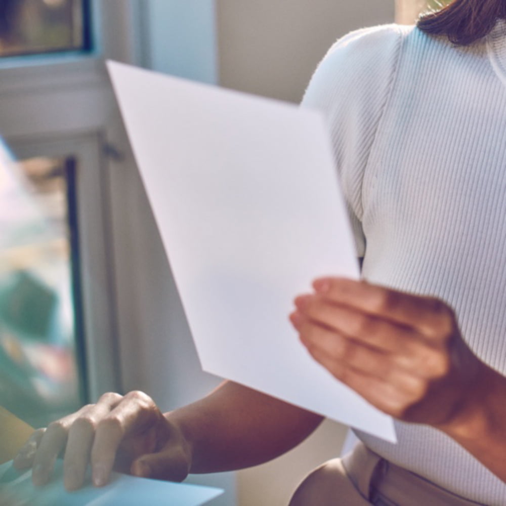 A person holding a sheet of paper.