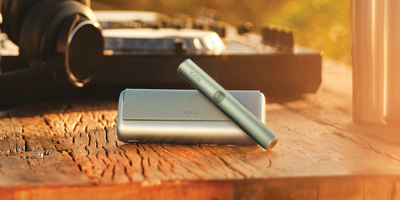 Two people holding phones over two cups of coffee.
