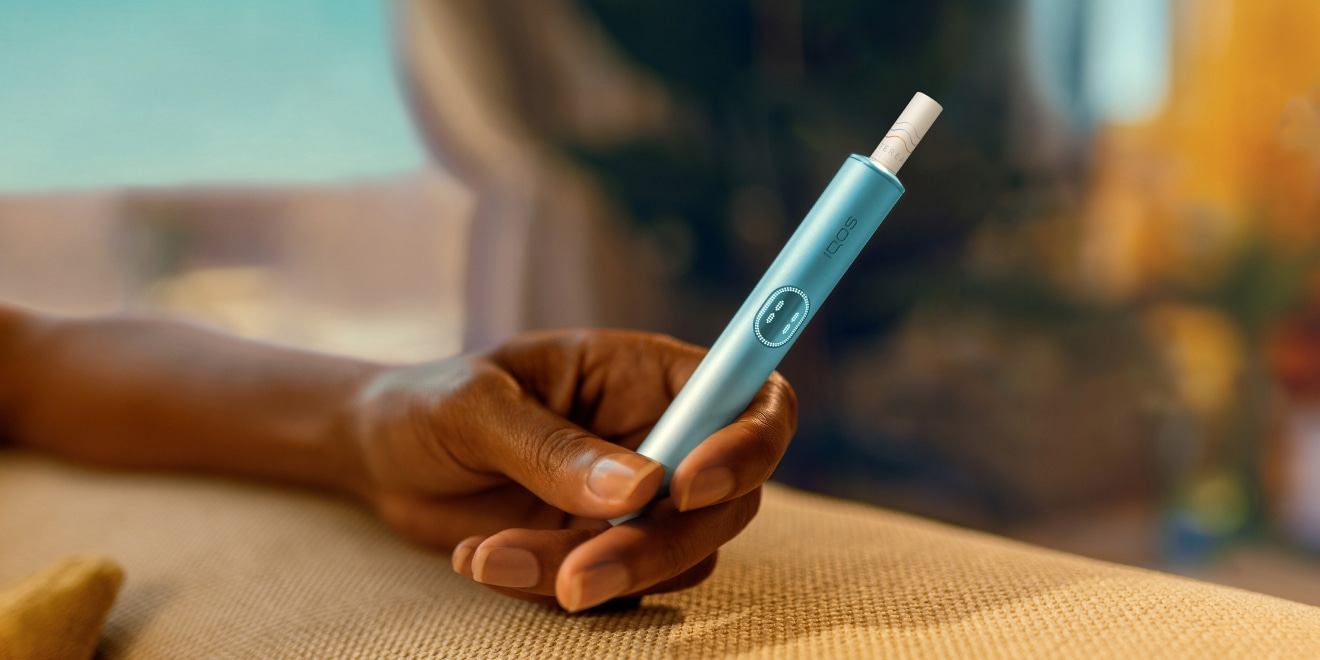 Hand holding an IQOS ILUMA device