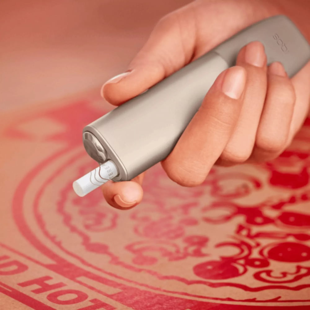 شخص يحمل جهاز IQOS ILUMA ONE.
