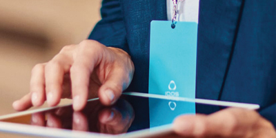 A passport, plane ticket, and IQOS device on a desk.