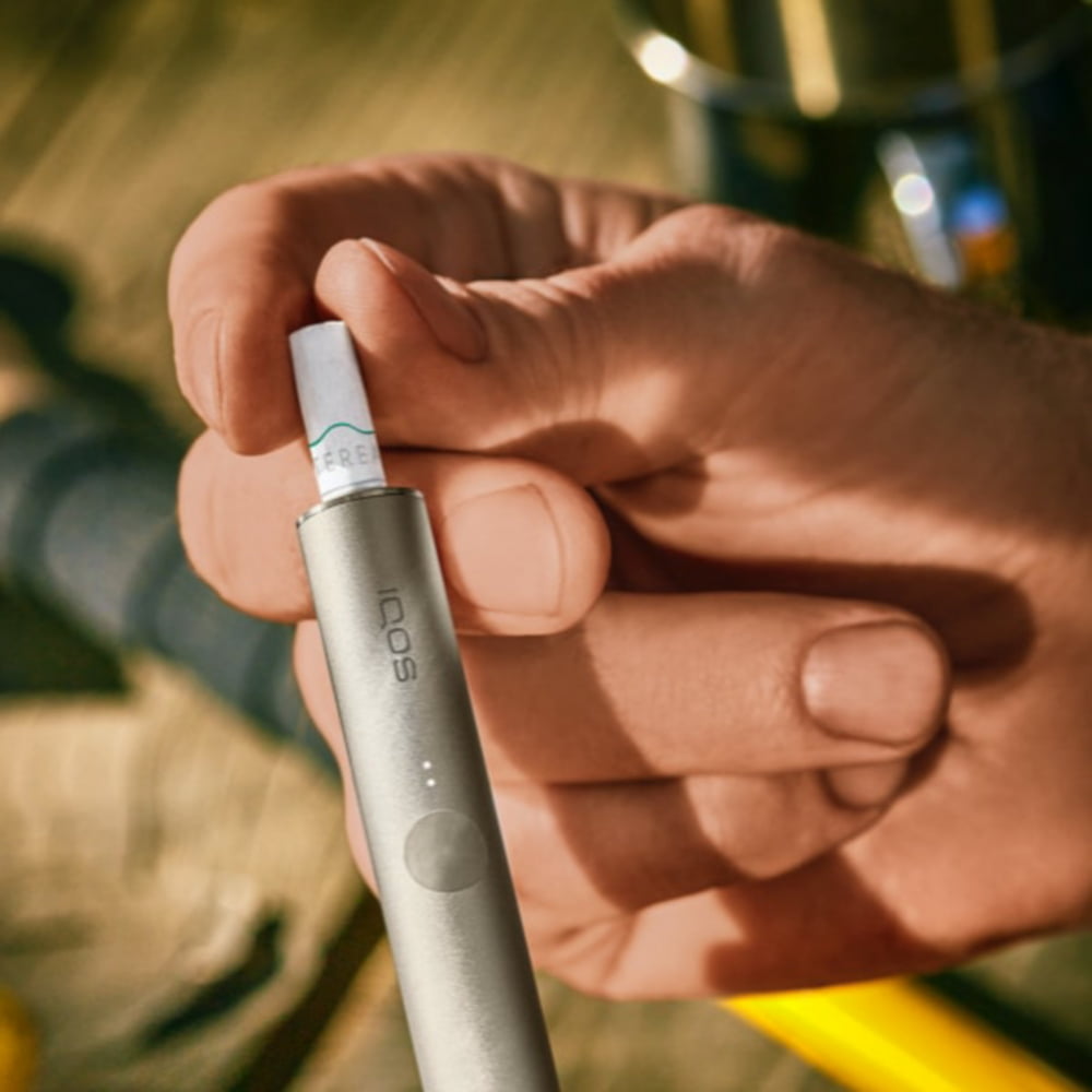 A person placing a TEREA stick into an IQOS ILUMA Holder. 