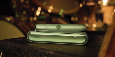 Two people holding phones over two cups of coffee.