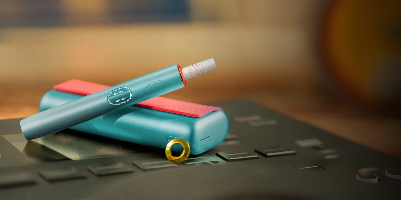 ثلاثة أجهزة من طراز IQOS ILUMA PRIME: أخضر زمرّدي، كامي ذهبيّ، بالإضافة إلى رماديّ داكن برونزيّ.