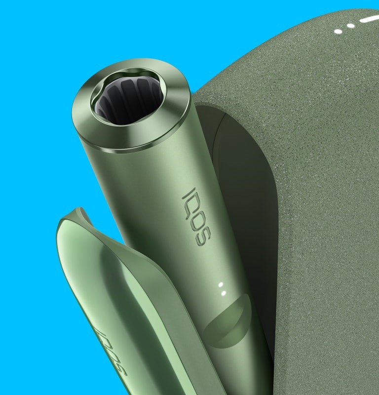 A Moss Green IQOS ILUMA device inside a Pocket Charger with its door open.