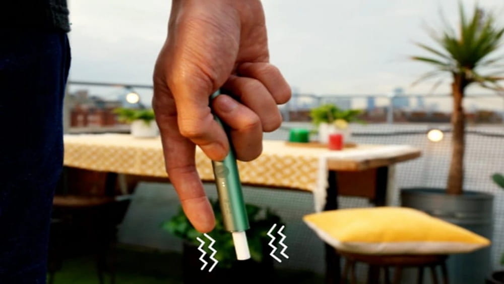 An illustration showing how IQOS ILUMA PRIME is responsive to hand gestures.