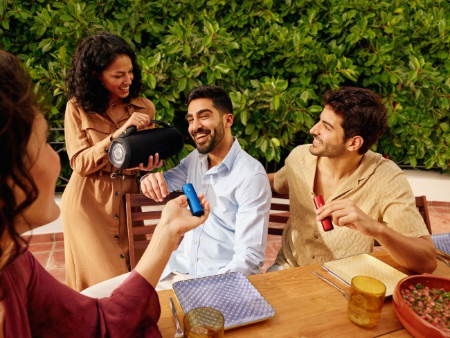 Two people talking, one of them is holding a blue BONDS by IQOS device Two people talking, one of them is holding a blue BONDS by IQOS device